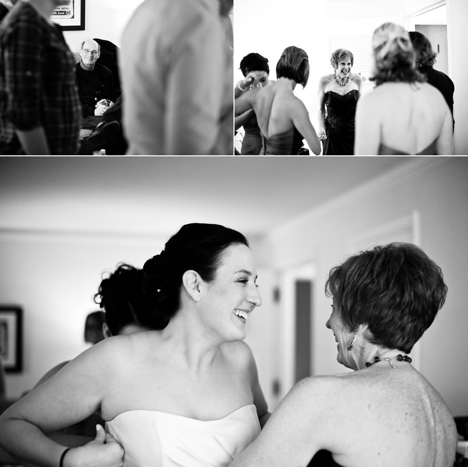 bride putting on dress with mother