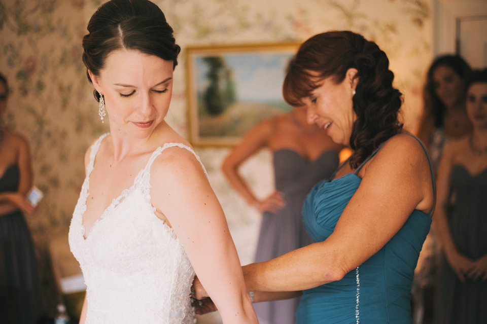 mother of the bride buttoning her dress