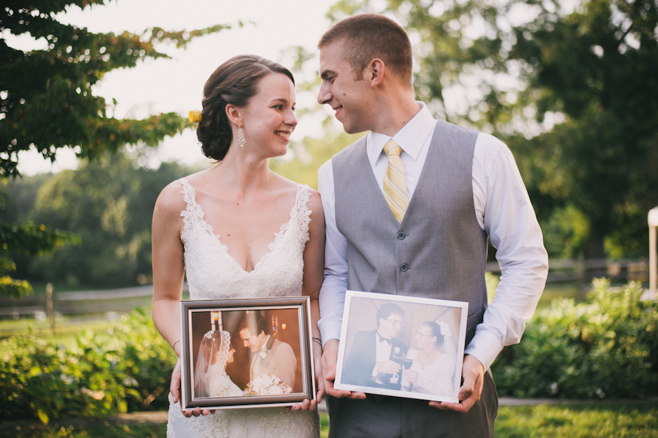 bride and groom holding photographs of their parents at their wedding