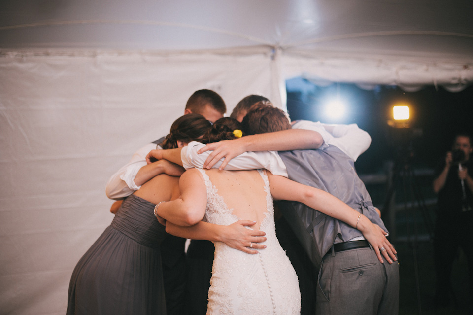 bride groom and siblings hugging on the dance floor